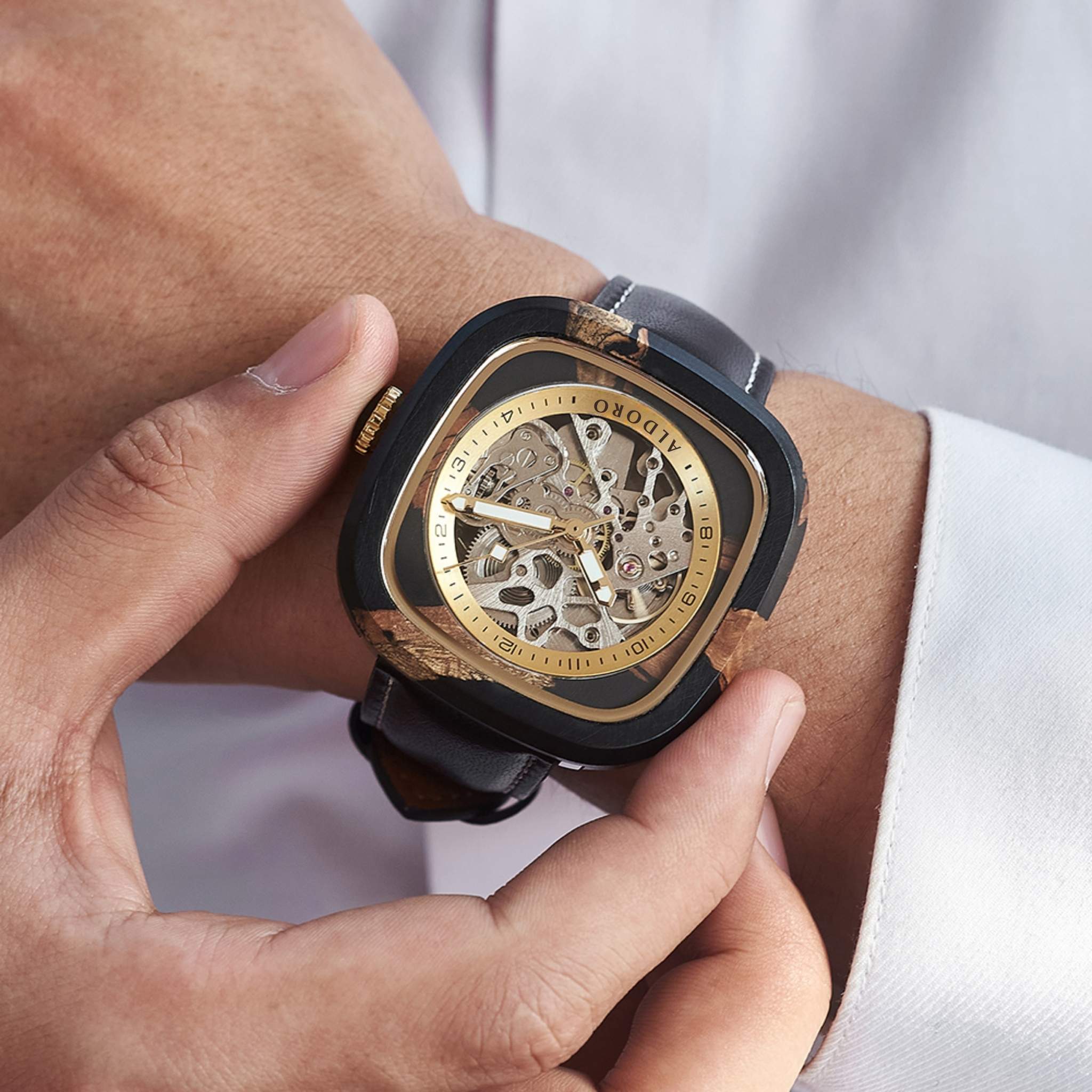 Close-up of a luxury wooden wristwatch with visible mechanical movement, worn on a man’s wrist, symbolizing Aldoro’s natural luxury and artisanal craftsmanship.